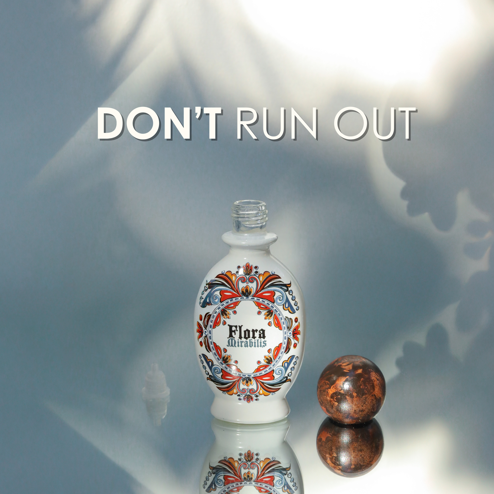 Empty Flora Mirabilis Holy Grail Face Oil bottle with wooden cap beside it and text overlay reading ‘Don’t Run Out.’