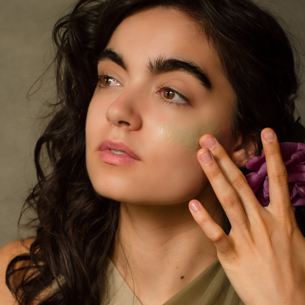Woman applying Fountain of Youth Cleansing Clay to her cheek