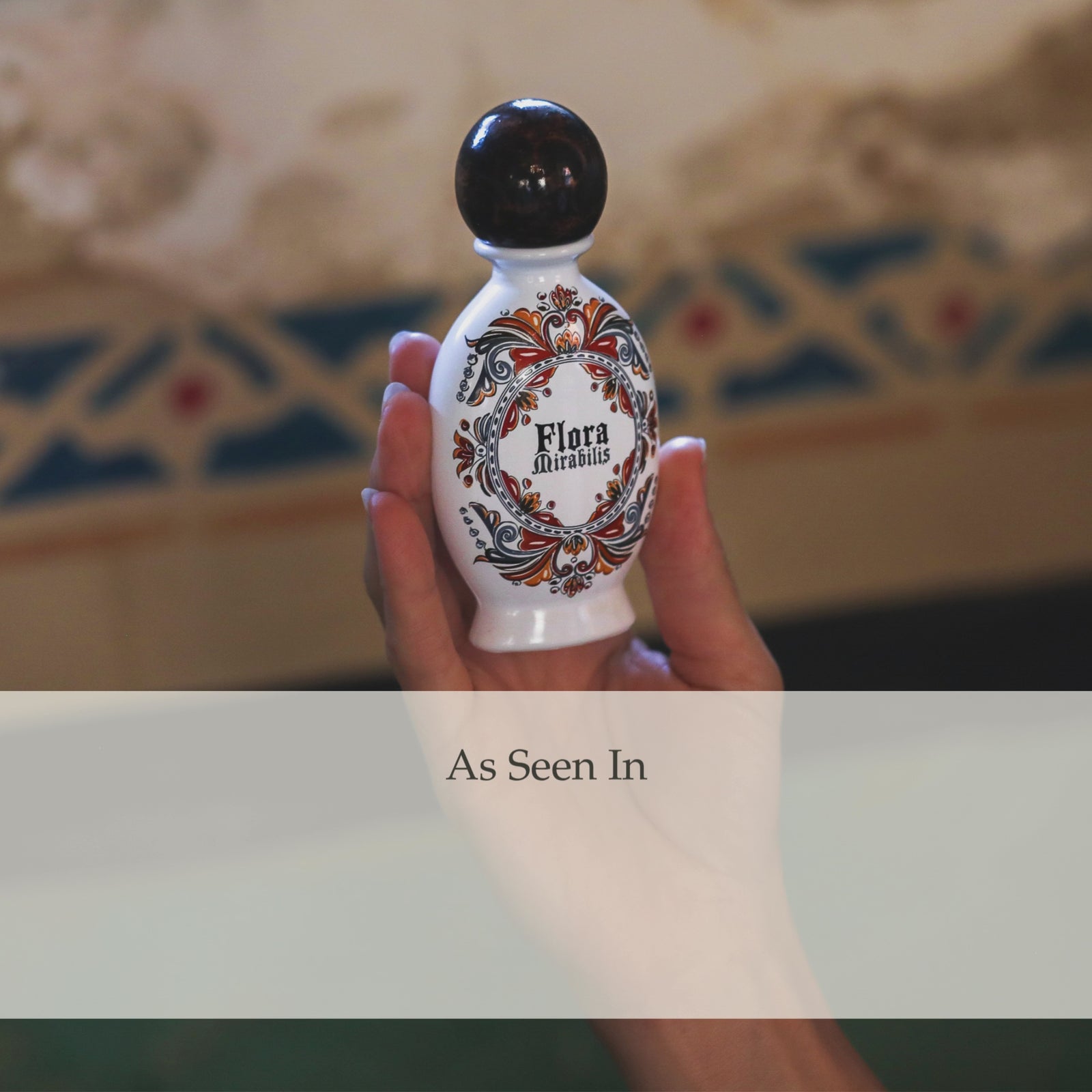 A looping animation showing the Flora Mirabilis Holy Grail Face Oil bottle while magazine and press quotes fade in and out behind it including GLAMOUR, Forbes, Town & Country, Santa Barbara Magazine, Bustle, Byrdie, and L'OFFICIEL.